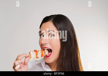 Ritratto di una donna di mangiare un shish kebab Foto Stock