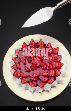 Angolo di alta vista di meringa alla fragola con una torta a server Foto Stock