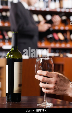 Mano d'uomo tenendo un bicchiere di vino Foto Stock