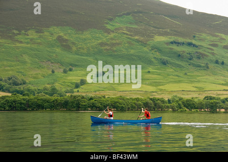 Vista laterale di 2 giovani adulti caucasici in canoa canadese su un Loch Earn deserto, Perthshire, Scozia. REGNO UNITO Foto Stock