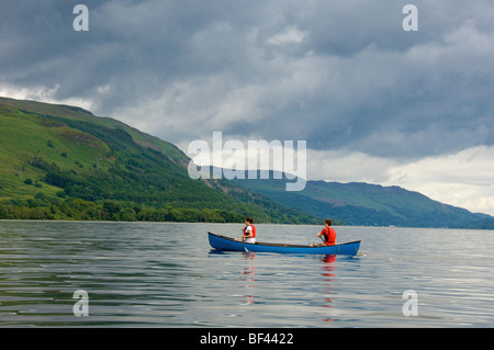 Vista laterale di 2 giovani adulti caucasici in canoa canadese su un Loch Earn deserto, Perthshire, Scozia. REGNO UNITO Foto Stock