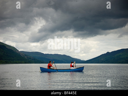 Giovane uomo e donna caucasica che si accosta a una canoa canadese su Loch Earn, Perthshire, Scozia. REGNO UNITO Foto Stock