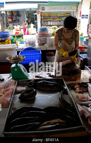 Donna preparare la preparazione di prodotti a base di pesce per la vendita nel mercato aereo aperto di Ho chi minh city Vietnam asia il Mercato Ben Thanh Foto Stock