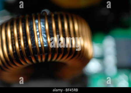 Macro Close-up di elettronica. Questa immagine illustra un induttore o trasformatore formata su di un toroide in una scheda a circuito stampato. Foto Stock