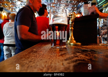 Mezza vuota piena di pinta di birra in un bar pub locali con licenza galway Irlanda Foto Stock