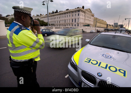 Nero di un funzionario di polizia utilizzando un laser fotocamera per catturare velocizzando gli automobilisti Foto Stock