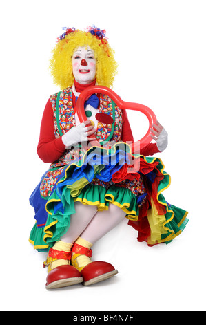 Clown seduto e tenendo un palloncino cuore Foto Stock