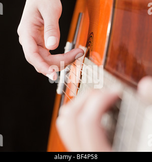 La donna a suonare la chitarra Foto Stock