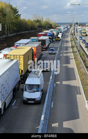 La polizia, distante, cerca di aggirare il traffico bloccato sul tratto stradale dell'autostrada M25 dopo la chiusura a causa di incidenti e ritardi molto lunghi Foto Stock