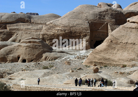 Turisti sul modo per l'ingresso di Petra, Giordania Meridionale ammirare alcune tombe. Foto Stock