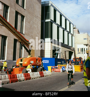 Ciclista passato di equitazione NHS San Barts ospedale nuovo sito in costruzione e lavoratori in Londra England Regno Unito KATHY DEWITT Foto Stock