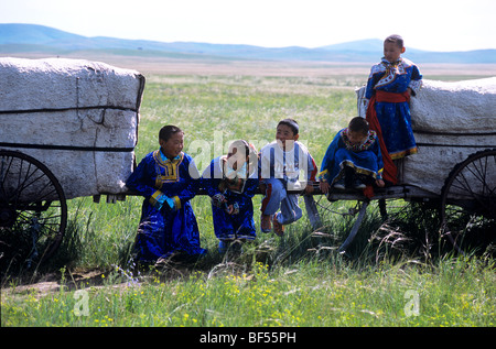 Il mongolo i bambini a giocare intorno la migrazione di carrelli, Xilin Gol prateria, Mongolia Interna Regione Autonoma, Cina Foto Stock