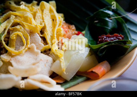 Nasi Goreng, un tradizionale Indonesiana riso fritto piatto su una foglia di banana con salsa al peperoncino Foto Stock