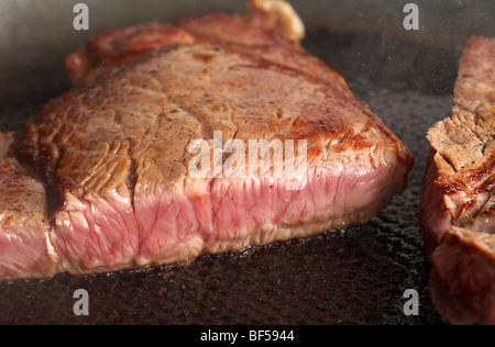 Fetta di mezzo raro chump steak di organic longhorn vacche irlandese friggere in una padella Foto Stock