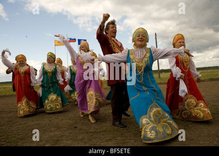 Gli uomini e le donne in costume tradizionale ballo nella danza rurale evento nel campo, Urali, Russia Foto Stock