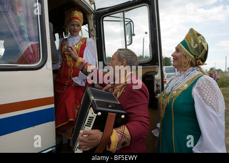 Tradizionale russo ballerini e il fisarmonicista in autobus a horse racing event, Urali, Russia Foto Stock