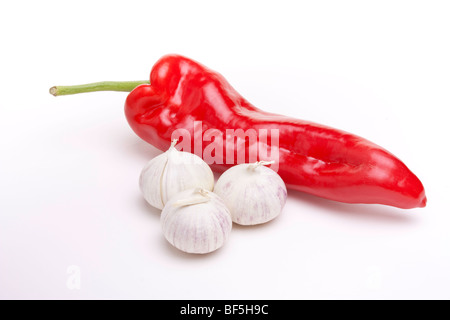 Grande rosso pepe dolce e piccolo italiano bulbi di aglio isolata contro uno sfondo bianco Foto Stock