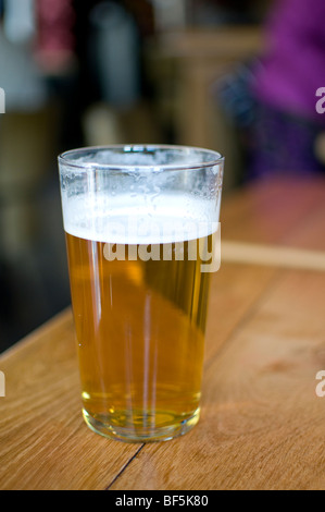 Una pinta di real ale pallido su un tavolo in un tipico pub inglese Foto Stock