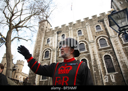 Un Beefeater racconta le storie della Torre di Londra per i turisti. Foto Stock