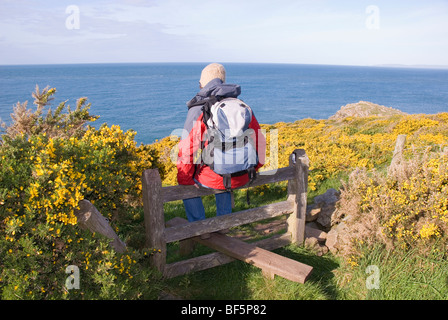 Camminatore di donna seduta su un montante verticale, Pembrokeshire, Wales, Regno Unito Foto Stock