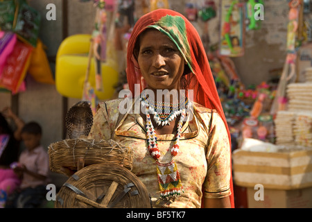 Un serpente incantatore la moglie cercando di fare il suo lavoro presso il festival di Pushkar nel Rajasthan in India Foto Stock