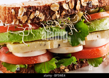 Salute vegetariani sandwich di pane con avocado, formaggio, funghi, lattuga, germogli e pomodori Foto Stock