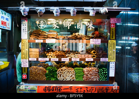 Una donna che lavorano dietro il suo chiosco di cibo nelle strade di Taiwan. Foto Stock