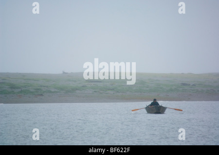 Pescatore in piccola barca dory sotto la pioggia e nebbia sul grande laguna, lagune di Humboldt State Park, California Foto Stock