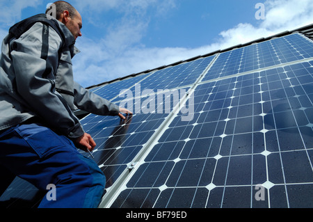 Controllo elettricista pannelli solari fotovoltaici sul tetto di una casa privata Foto Stock