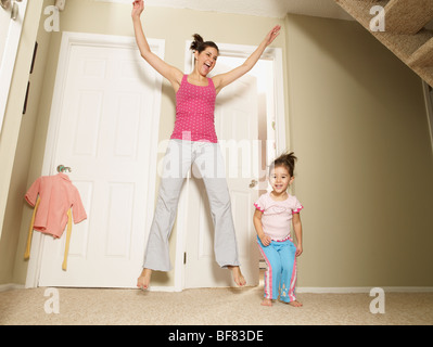 Madre e figlia saltando in casa Foto Stock