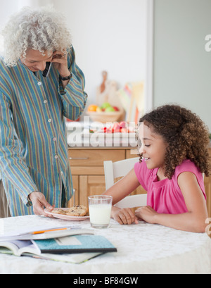 Nonna che serve la nipote di cookie Foto Stock