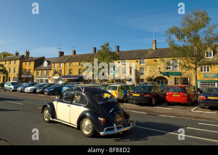 Volkswagen maggiolino guidando lungo la High Street a Moreton-in-Marsh Gloucestershire in Inghilterra Foto Stock