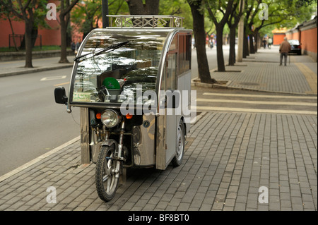 Un triciclo parcheggiato su un marciapiede in Dongcheng, Pechino CN Foto Stock