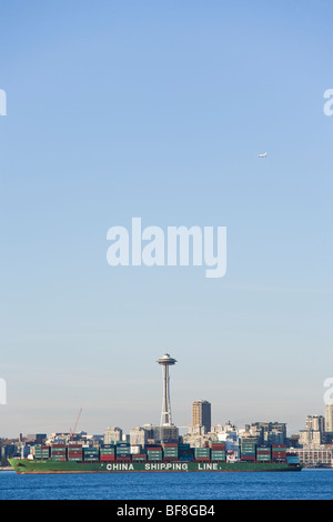 Una nave piena di contenitori su Elliott Bay sotto lo Space Needle. Un aereo in aria al di sopra di Seattle, WA, Stati Uniti d'America. Foto Stock