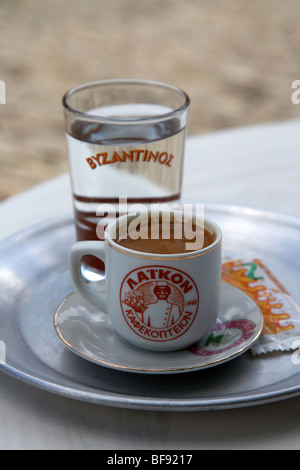 Il caffè turco noto come caffè cipriota nella repubblica di cipro europa servito con un bicchiere di acqua per uso potabile in seguito Foto Stock