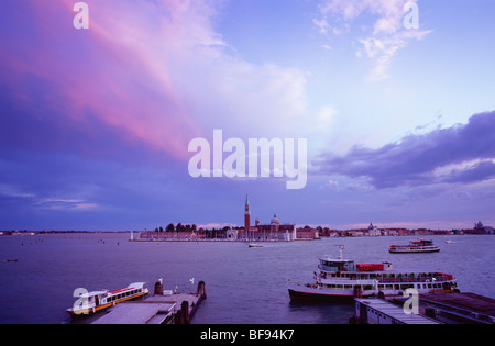 Vista sul canale di San Marco a San Giorgio Maggiore sotto un cielo drammatico al tramonto visto dalla principale isola Foto Stock