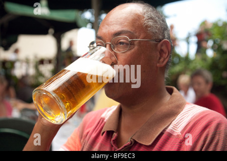 Di mezza età uomo indiano di bere una pinta di birra lager Foto Stock