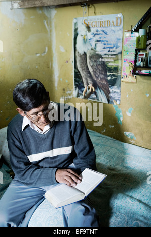 A condannare la lettura della Bibbia nella sua piccola cella camera in San Pedro prigione, La Paz, Bolivia. Foto Stock