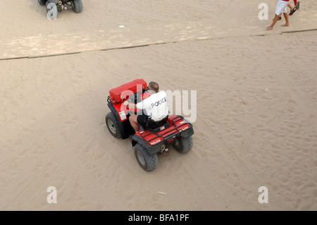 Pattuglia di polizia spiaggia su quad. Foto Stock