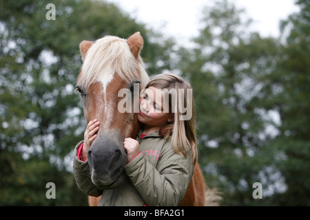 Cavalli domestici (Equus przewalskii f. caballus), ragazza caressfully abbracciando la testa di un cavallo, Germania Foto Stock