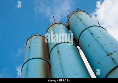 Tre blu silos arrugginito contro il cielo blu Foto Stock