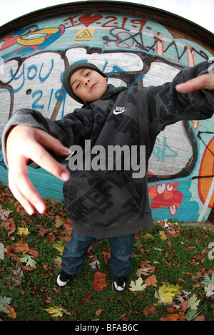 Ragazzo giovane dando atteggiamento da muro di graffiti Foto Stock