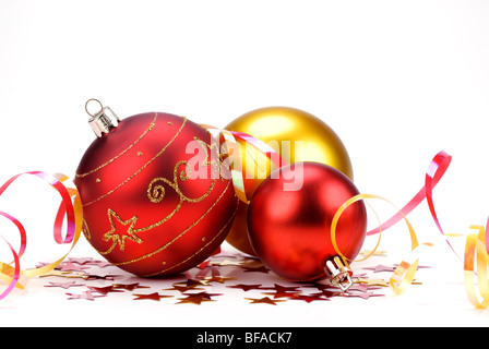 Tre lucidato le palle di Natale con nastri colorati su sfondo bianco Foto Stock