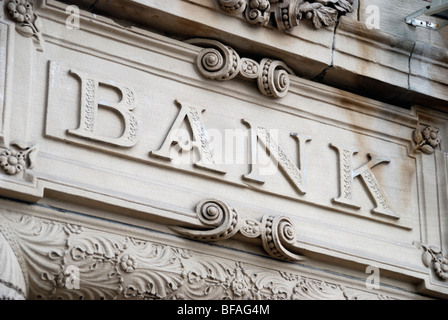 Vecchia pietra intagliata ' Banca ' segno sulla parte esterna dell'edificio Foto Stock