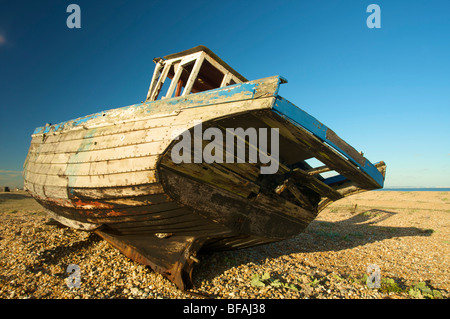 Vecchia barca lavato fino e lasciati a marcire sulla spiaggia Foto Stock