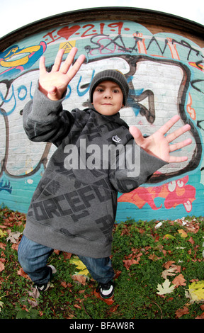 Ragazzo giovane dando atteggiamento da muro di graffiti Foto Stock