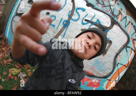 Ragazzo giovane dando atteggiamento da muro di graffiti Foto Stock