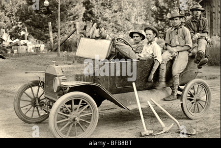 Quattro operai con strumenti nel modello T Ford Foto Stock