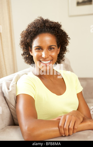 Donna rilassante sul divano di casa Foto Stock