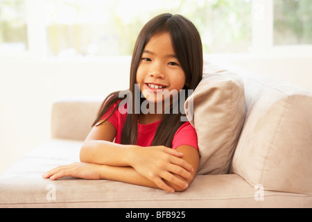 Giovane ragazza rilassante sul divano di casa Foto Stock